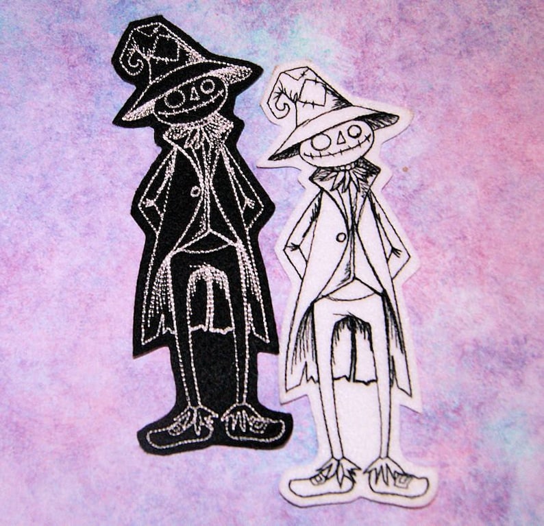 May include: Two black and white embroidered iron-on patches of a whimsical character wearing a hat and a long coat. The character has a stitched-on smile and a stitched-on nose.