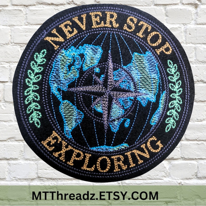May include: Embroidered patch with a black background, a blue and green globe with a compass, and the text "NEVER STOP EXPLORING" in gold lettering.