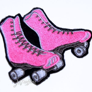 May include: Pink roller skate patch with black and gray details. The patch is embroidered and has a vintage style.