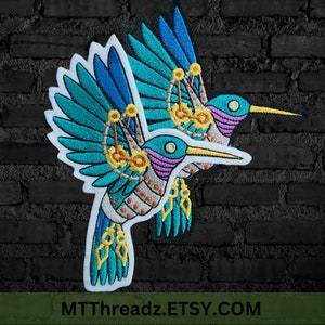 May include: A pair of embroidered iron-on patches featuring a steampunk hummingbird design with intricate details in shades of blue, green, purple, and gold. The patches are perfect for adding a unique touch to clothing, bags, or other accessories.