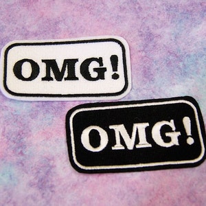 May include: Two iron-on patches with the text "OMG!" in black and white. The top patch is white with black text and the bottom patch is black with white text.