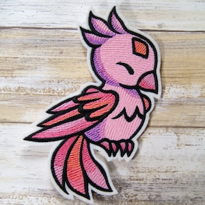 May include: Pink and orange embroidered bird patch with a smiling face and a closed eye. The bird has a black outline and is perched on a white background.