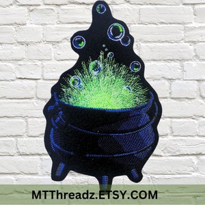 May include: A black cauldron with green bubbling liquid and blue accents. The cauldron is on a white brick background.  MTTThreadz.ETSY.COM