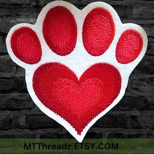 May include: Embroidered patch in the shape of a paw print with a heart. The paw print is white with red embroidered details. The heart is red. The text "MTThreadz.ETSY.COM" is at the bottom.