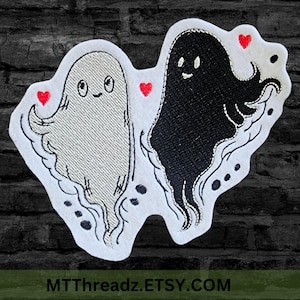 May include: Embroidered patch featuring two friendly ghost figures, one light grey and one black, each with a smiling face and red heart accents. The patch has a white border and the text MTThreadz.ETSY.COM.