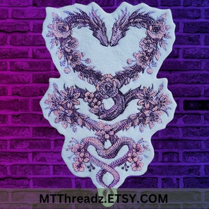 May include: Embroidered patch featuring two intertwined snakes forming a heart shape with floral accents. The snakes are outlined in pink and the flowers are pink and purple.