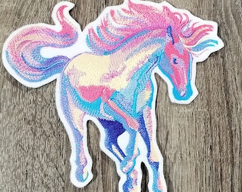 May include: A colorful embroidered patch of a horse running with a flowing mane and tail. The horse is a light blue, pink, and yellow color.