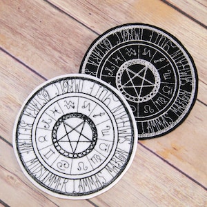 May include: Two black and white embroidered patches with a pentagram in the center and a circle of astrological signs around it. The text around the outer edge of the patches reads "BE WISE", "MIDSUMMER", "LAMMAS", "MABON", "SAMHAIN", "YULE", "IMBOLC", "OSTARA".