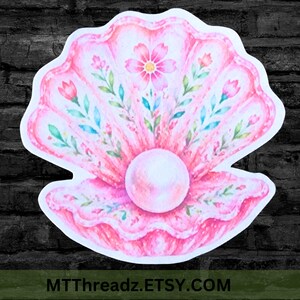 May include: A die-cut sticker featuring a watercolor illustration of an open pink seashell with a central white pearl. The shell is decorated with delicate floral patterns in shades of pink, green, and blue. The text MTTTHREADZ.ETSY.COM is visible.