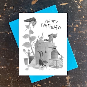 May include: A black and white illustrated birthday card featuring a raccoon, a skunk, a bird, and a mouse. The card reads "Happy Birthday!"