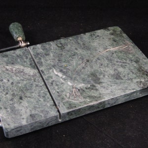 May include: Green marble cheese board with a built-in wire cheese slicer and a green marble handle.
