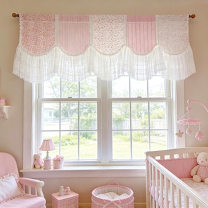 May include: A pink and white nursery with a window featuring a valance with floral and striped patterns, trimmed with white lace. The room includes a crib, a rocking chair, and a shelf with toys, all in shades of pink.