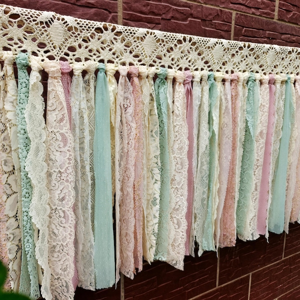 Cortina de renda artesanal em estilo boho shabby chic, em tons suaves de verde sálvia e malva acinzentado, ideal para decoração de janelas em estilo casa de campo francesa ou para criar um ambiente aconchegante para casamentos.