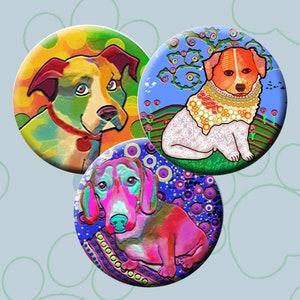 Könnte beinhalten: Drei bunte 1,5 Zoll große Anstecknadeln mit verschiedenen Hunderassen. Die erste Nadel zeigt einen weißen und braunen Hund mit grünen, gelben und orangefarbenen Punkten. Die zweite Nadel zeigt einen weißen Hund mit rotem Kopf und einem blauen, grünen und gelben Blumendesign. Die dritte Nadel zeigt einen rosa Dackel vor einem blauen, violetten und grünen Hintergrund.