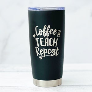 K&ouml;nnte beinhalten: Ein schwarzer Edelstahlbecher mit einer wei&szlig;en Aufschrift "Coffee Teach Repeat" mit einem kleinen Kaffeetassen-Symbol und einem Pfeil.