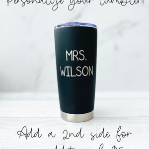 K&ouml;nnte beinhalten: Schwarzer Edelstahlbecher mit dem eingravierten Text "MRS. WILSON" auf der Seite. F&uuml;gen Sie eine zweite Seite f&uuml;r zus&auml;tzliche 5 &euro; hinzu.