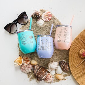 K&ouml;nnte beinhalten: Drei Edelstahlbecher mit sommerlichen Spr&uuml;chen. Die Becher sind t&uuml;rkis, lavendel und rosa. Die Spr&uuml;che lauten "Salt Life Little Beach", "Summer Vibes" und "Sun Sand and a Drink in My Hand Girls Trip 2022".