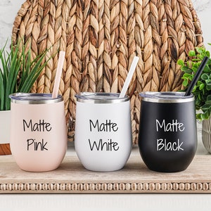 K&ouml;nnte beinhalten: Drei Edelstahlbecher mit Deckel und Strohhalmen. Die Becher sind mattrosa, wei&szlig; und schwarz. Jeder Becher tr&auml;gt die Aufschrift "Matte" und die Farbe des Bechers.