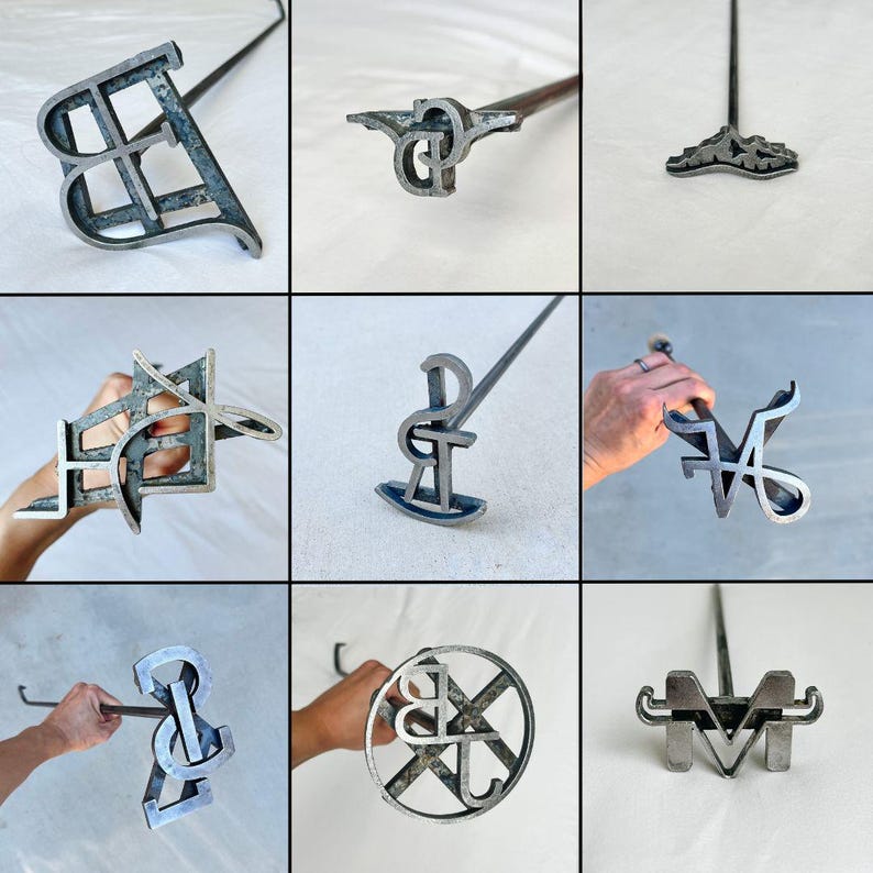 May include: Nine different metal branding irons with wooden handles. The branding irons are shaped like letters and symbols, including a "B", "P", "M", "V", "R", "S", "J", and a combination of "B" and "J".