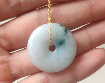 Può includere: Un ciondolo in giada bianca con un design a spirale verde, appeso a una catena d'oro.