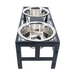 May include: Black metal elevated dog bowl stand with two stainless steel bowls.