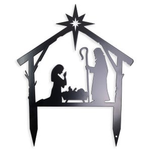 Puede incluir: Silueta negra de metal de la escena de la natividad con una estrella en la parte superior. Las figuras incluyen a Mar&iacute;a, Jos&eacute; y el ni&ntilde;o Jes&uacute;s en un pesebre. La silueta est&aacute; dise&ntilde;ada para ser utilizada como una estaca de jard&iacute;n.