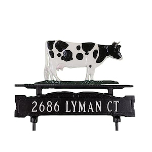May include: Black and white cow figurine on a black metal mailbox topper with the address 2686 Lyman Ct.