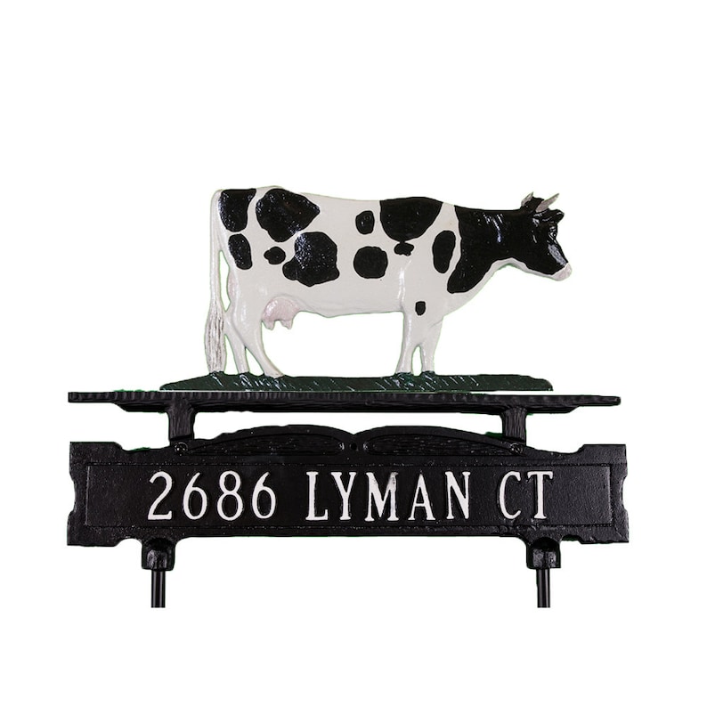 May include: Black and white cow figurine on a black metal mailbox topper with the address 2686 Lyman Ct.