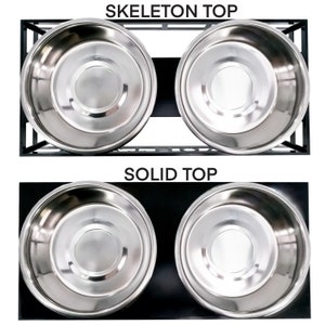 May include: Two stainless steel dog bowls on a black stand. The stand has a solid top and a skeleton top.  The bowls are elevated.