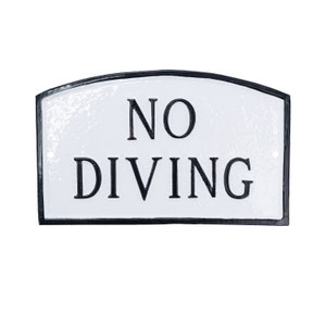 May include: White sign with black border and rounded top. The sign reads "NO DIVING" in black lettering.