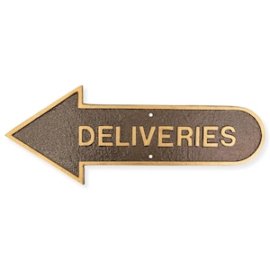 May include: A brown metal arrow sign with a gold outline and the word "DELIVERIES" in gold lettering. The arrow points to the left.