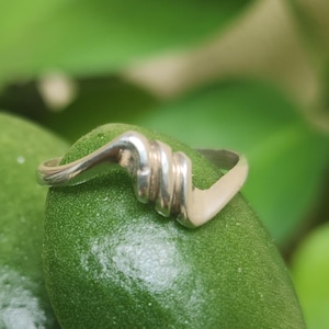 Könnte beinhalten: Rustikales Holzschild mit dem Text "Welcome to our home" in weißer Schrift. Das Schild hat eine Used-Optik und ein schlichtes, einladendes Design, ideal für die Eingangsbereichsdekoration.