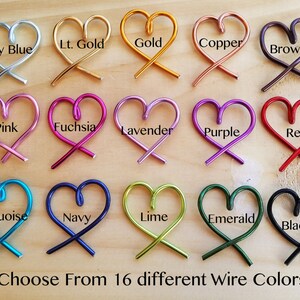 May include: A display of 16 different colored wire heart shapes, each with a label indicating its color. The colors include sky blue, light gold, gold, copper, brown, pink, fuchsia, lavender, purple, red, turquoise, navy, lime, emerald, and black. The text "Choose From 16 different Wire Colors" is at the bottom of the image.