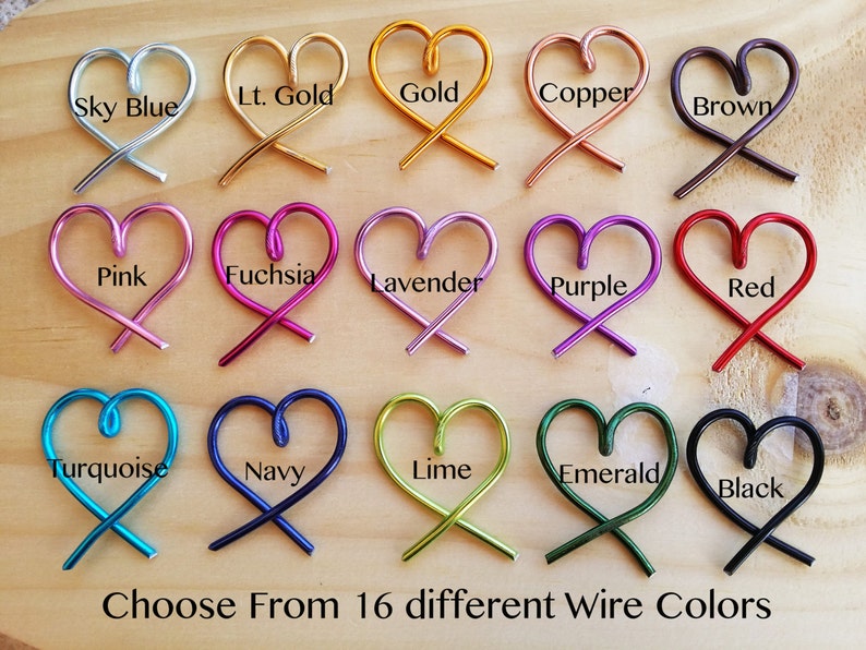 May include: A display of 16 different colored wire heart shapes, each with a label indicating its color. The colors include sky blue, light gold, gold, copper, brown, pink, fuchsia, lavender, purple, red, turquoise, navy, lime, emerald, and black. The text "Choose From 16 different Wire Colors" is at the bottom of the image.