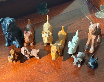Colecciones de figuritas de perros miniatura vintage talladas en madera y otras piezas.