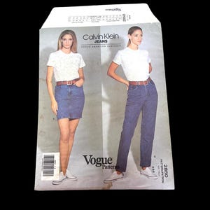 May include: A vintage Vogue pattern featuring Calvin Klein Jeans. The cover shows two models wearing denim skirts and jeans with white t-shirts. The pattern includes the Vogue and Calvin Klein Jeans logos.