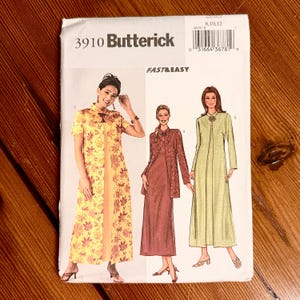 May include: A Butterick 3910 sewing pattern envelope featuring illustrations of three long dresses with matching jackets. The designs include a yellow floral print, a solid maroon, and a solid light green option, all labeled as Fast & Easy.