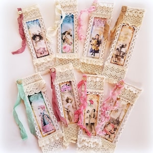 May include: A collection of vintage-style bookmarks. Each bookmark features a rectangular image with a sepia-toned photograph, framed by cream-colored lace and adorned with a ribbon and button. The images depict women, couples, and the Eiffel Tower.