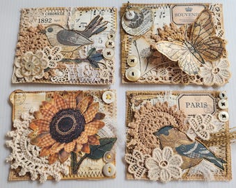 May include: Four rectangular mixed-media art pieces featuring vintage-style paper backgrounds, beige crochet lace, and cream-colored buttons. Designs include a bird, a butterfly, a sunflower, and a bird with the text Paris printed on a label.