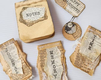 May include: A collection of vintage-style paper ephemera including a small notepad labeled NOTES, a tag labeled HAPPY THOUGHTS, and three rectangular cards labeled JOURNAL, MEMORY, and TIME, all featuring aged dictionary page textures.
