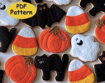 May include: A collection of felt Halloween-themed ornaments including white ghosts, black cats, orange pumpkins, and candy corn shapes in yellow, orange, and white. A yellow oval overlay with the black text PDF Pattern is visible.