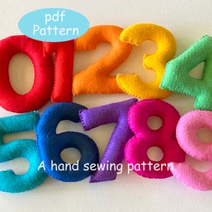Peut inclure: Chiffres en feutre cousus à la main, de 0 à 9, dans des couleurs vives : rouge, orange, jaune, vert, bleu, violet, rose et rose clair. Le texte "pdf Pattern" et "A hand sewing pattern" est inclus.
