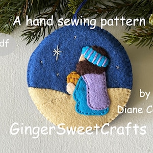 Puede incluir: Un patrón de adorno navideño de fieltro cosido a mano. El adorno presenta una figura en azul, morado y marrón contra un cielo estrellado azul y un suelo beige. El texto incluye "A hand sewing pattern" y "GingerSweetCrafts".