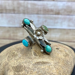 Puede incluir: Un anillo de plata con un diseño de flor turquesa y cuatro piedras turquesa.