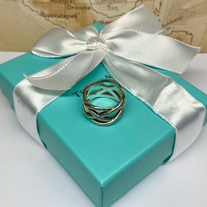 May include: A silver ring with a woven design, in a Tiffany & Co. turquoise box with a white satin ribbon.