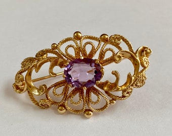Vintage brosch i 14 karat gult guld med ametist: Looping rep-design