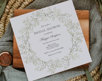 May include: A white bridal shower invitation with a floral wreath border. The invitation reads "Join us for a Bridal Shower to celebrate Maggie Simpson. Saturday, July 18 at 2pm. Willow Farm, 786 Evergreen Lane, City, State 12345. RSVP to Anne 457-767-9888. Registered at Target."