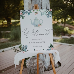 May include: Welcome sign for a baby shower featuring a watercolour design of a teapot, flowers, and foliage. The sign reads "Welcome Olivia's Baby Shower August 12, 20XX".