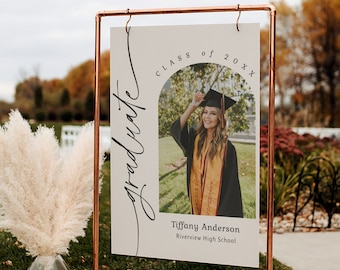 Peut inclure: Une pancarte blanche avec du texte noir qui dit "Classe de 20XX Diplômé". Une photo d'une personne portant une toque et une robe de fin d'études est au centre de la pancarte. Le texte "Tiffany Anderson Riverview High School" est sous la photo.