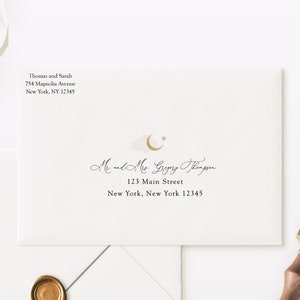 May include: A white envelope with elegant calligraphy, addressed to "Mr. and Mrs. Gregory Thompson" at 123 Main Street, New York, NY 12345. The return address is "Thomas and Sarah, 754 Magnolia Avenue, New York, NY 12345." A gold wax seal and a wooden stamp are also visible.
